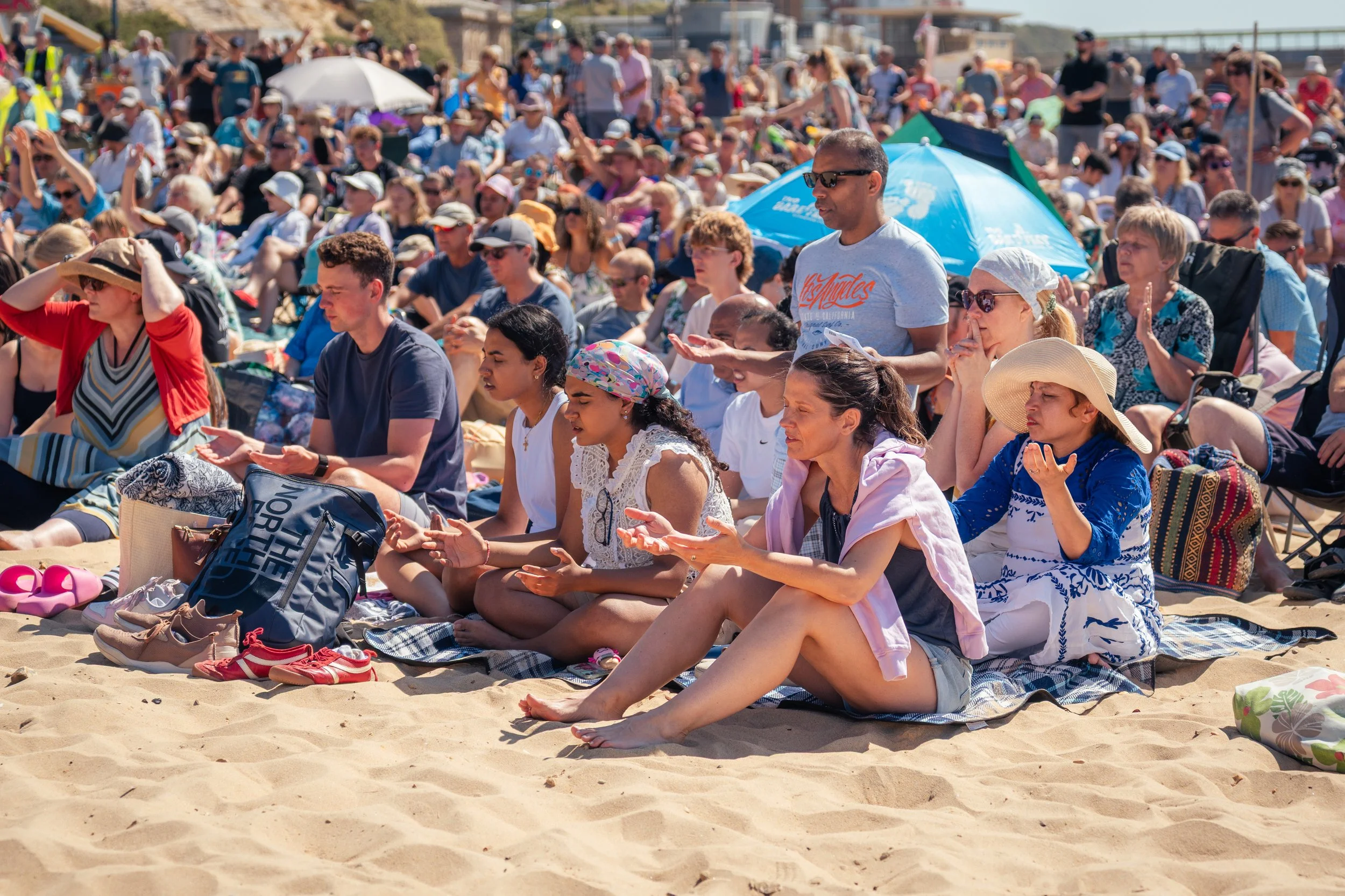 A large group of people at a beach baptism