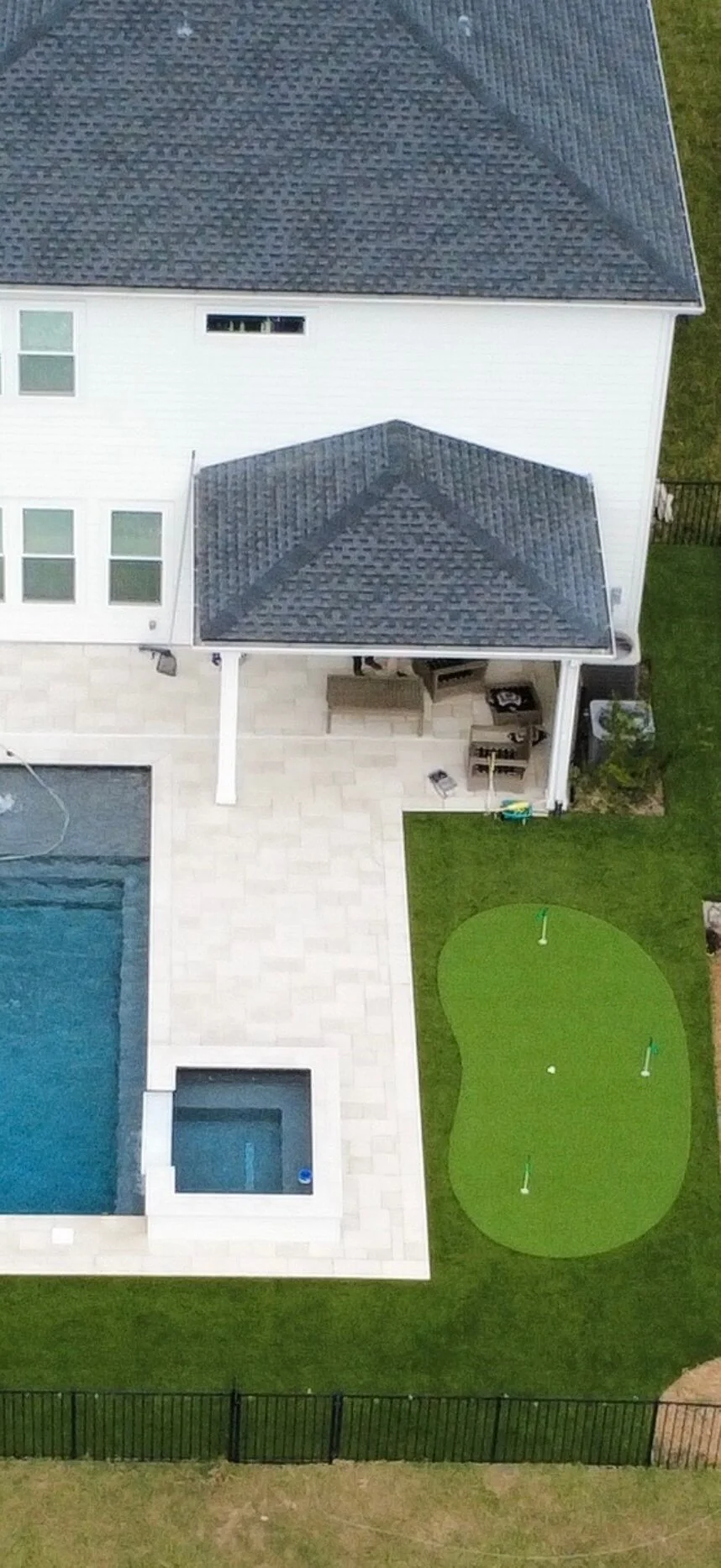 Aerial view of artificial turf backyard with pool and putting green in Jacksonville FL