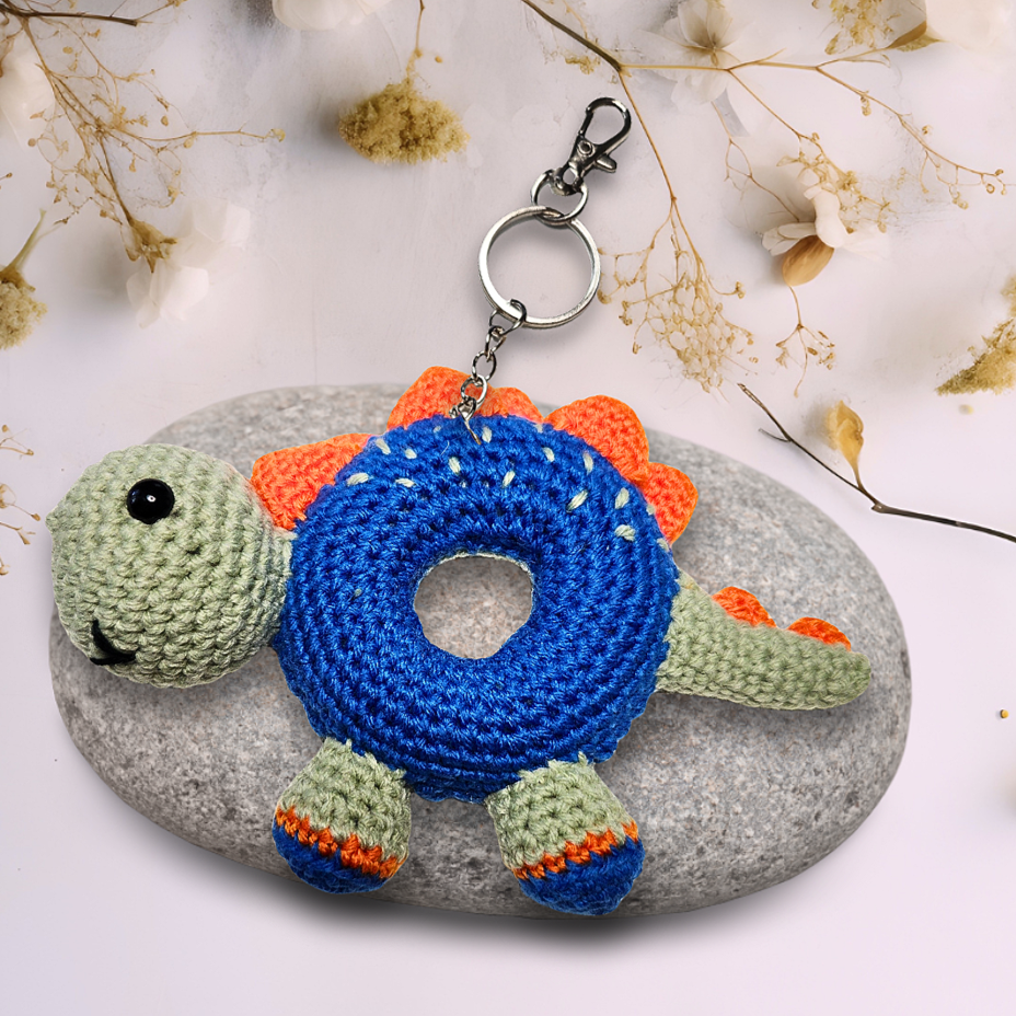 blue crochet stegosaurus doughnut with orange spikes on keychain