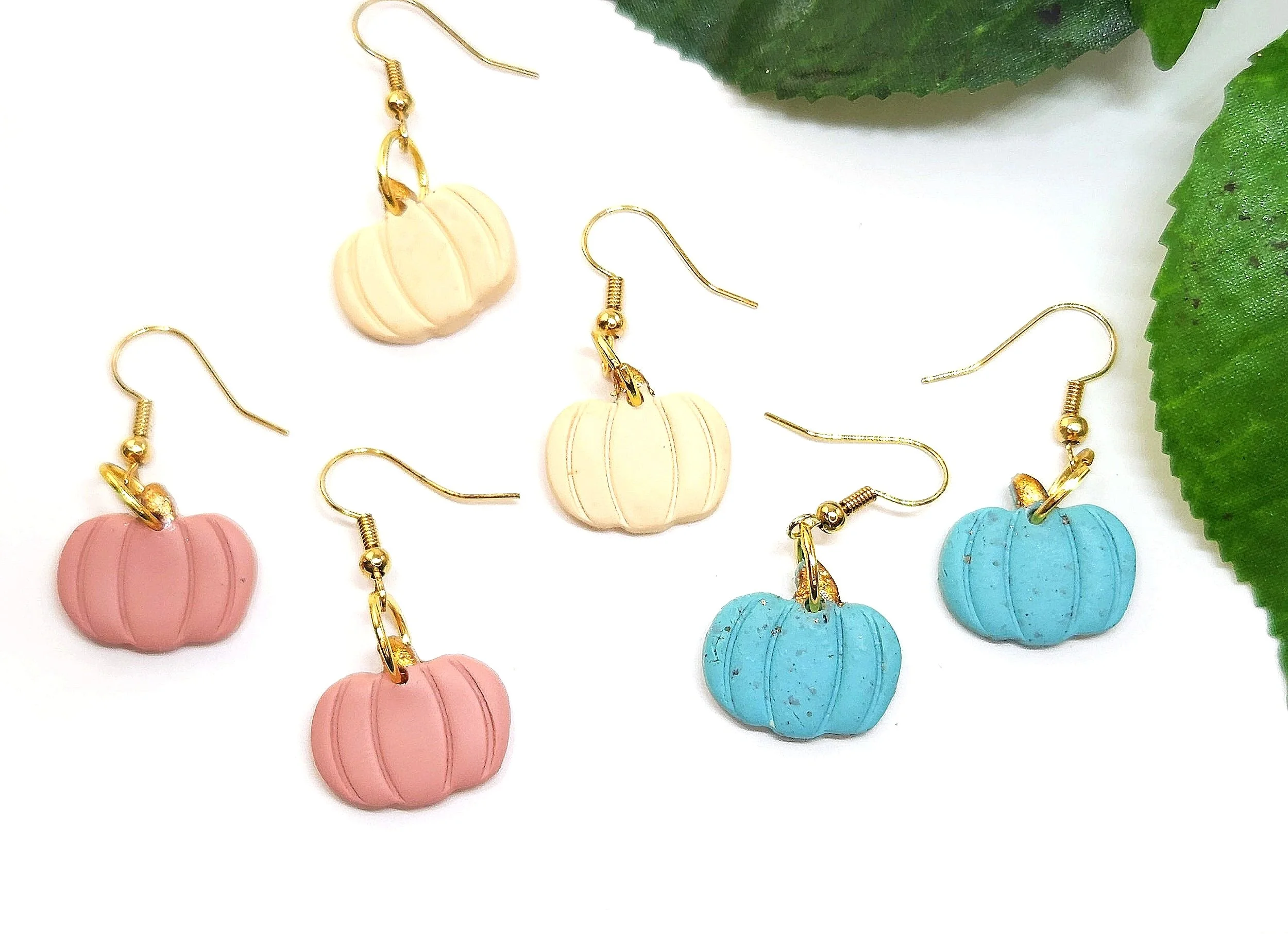 three pair of clay pumpkin earrings in blush, cream and turquoise