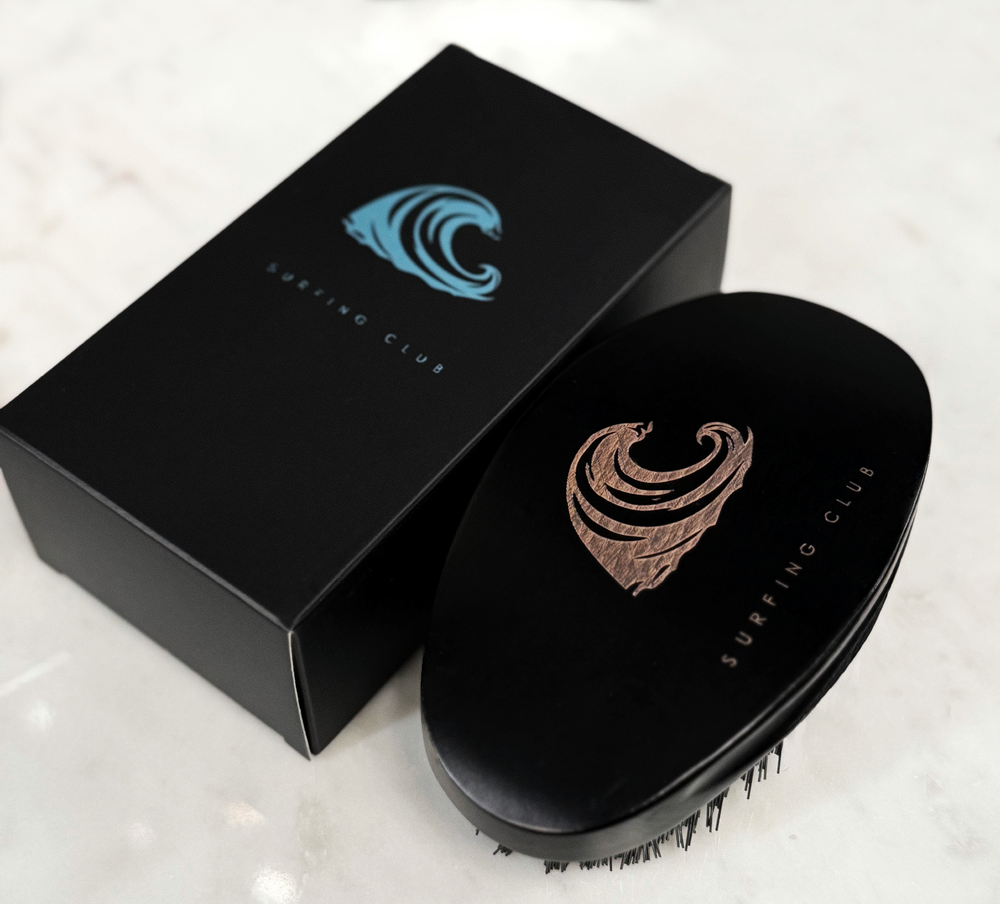 Wave Surfing Club branded brush on a dark background