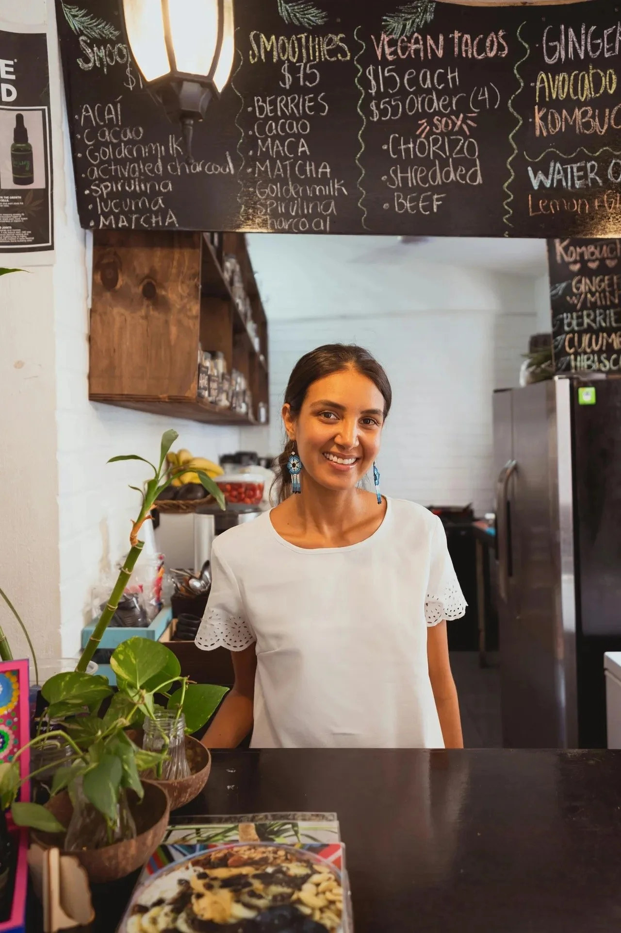Woman smiling behind counter of a restaurant