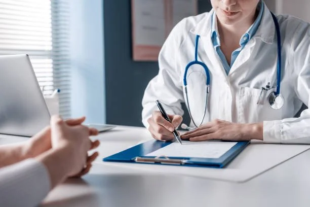 Doctor in white coat with stethoscope consulting with patient in medical office