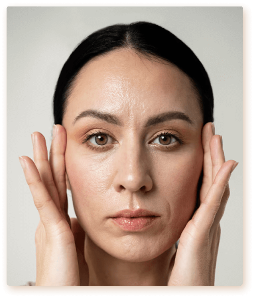 A woman touching her face with both hands, close-up portrait with neutral expression and clear skin.