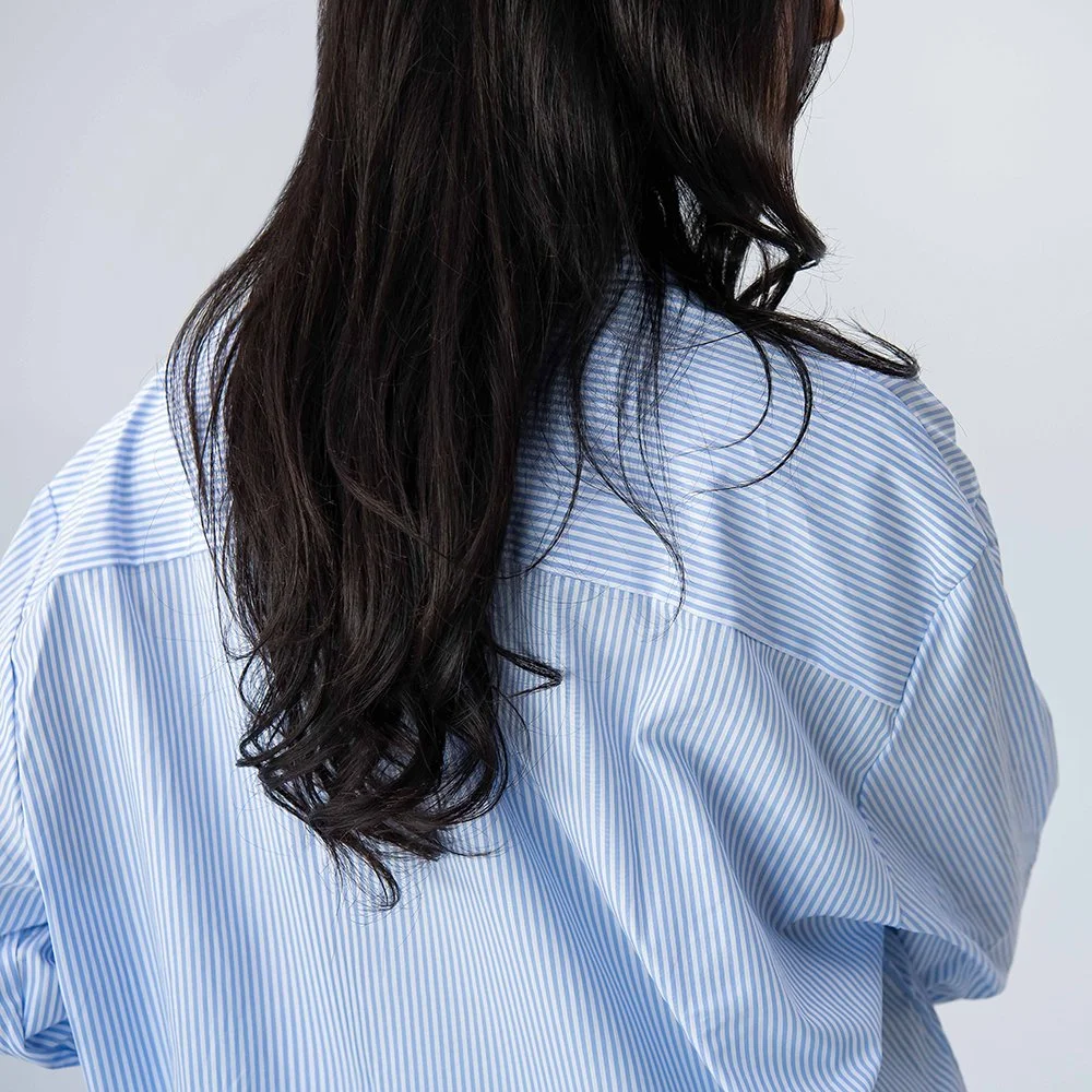 Detailaufnahme der Rückseite eines hellblau-weiss gestreiften Baumwollhemds, hochwertige Verarbeitung, made in Italy.