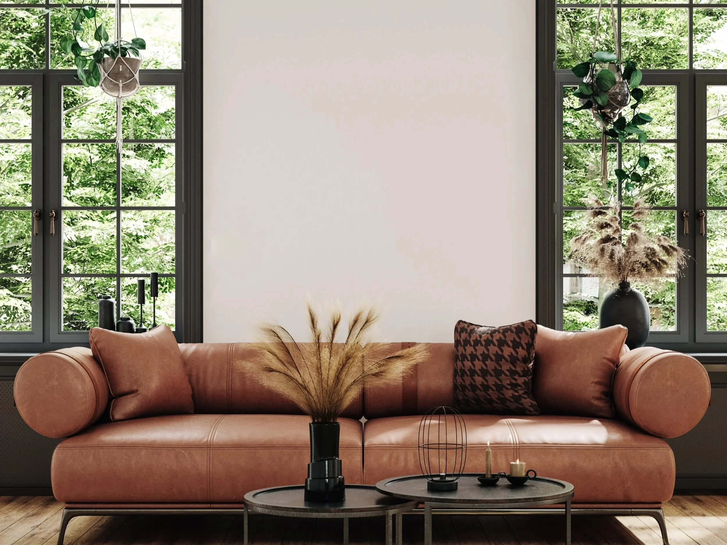 Living room with large front windows showing green trees outside, pink velvet sofa with decorative pillows, and coffee tables with candles and decorative items.