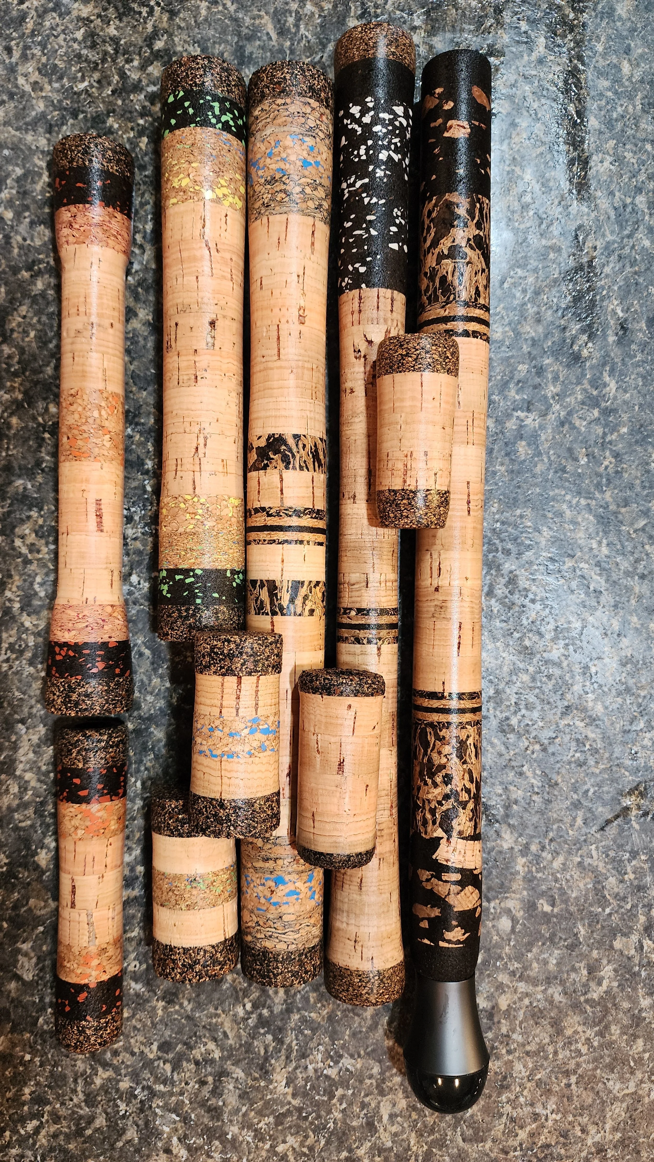 A collection of various corks from wine bottles laid out on a dark, textured surface.