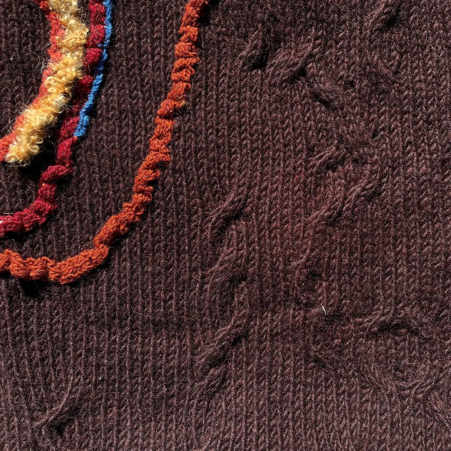 Organic Cabling with knitted ripples. 
Using only a rough sketch for composition, each cable is crossed at my discretion during the knitting. The same is done for the wooly red ripples. 
The result is a completely unique blanket that ties the design