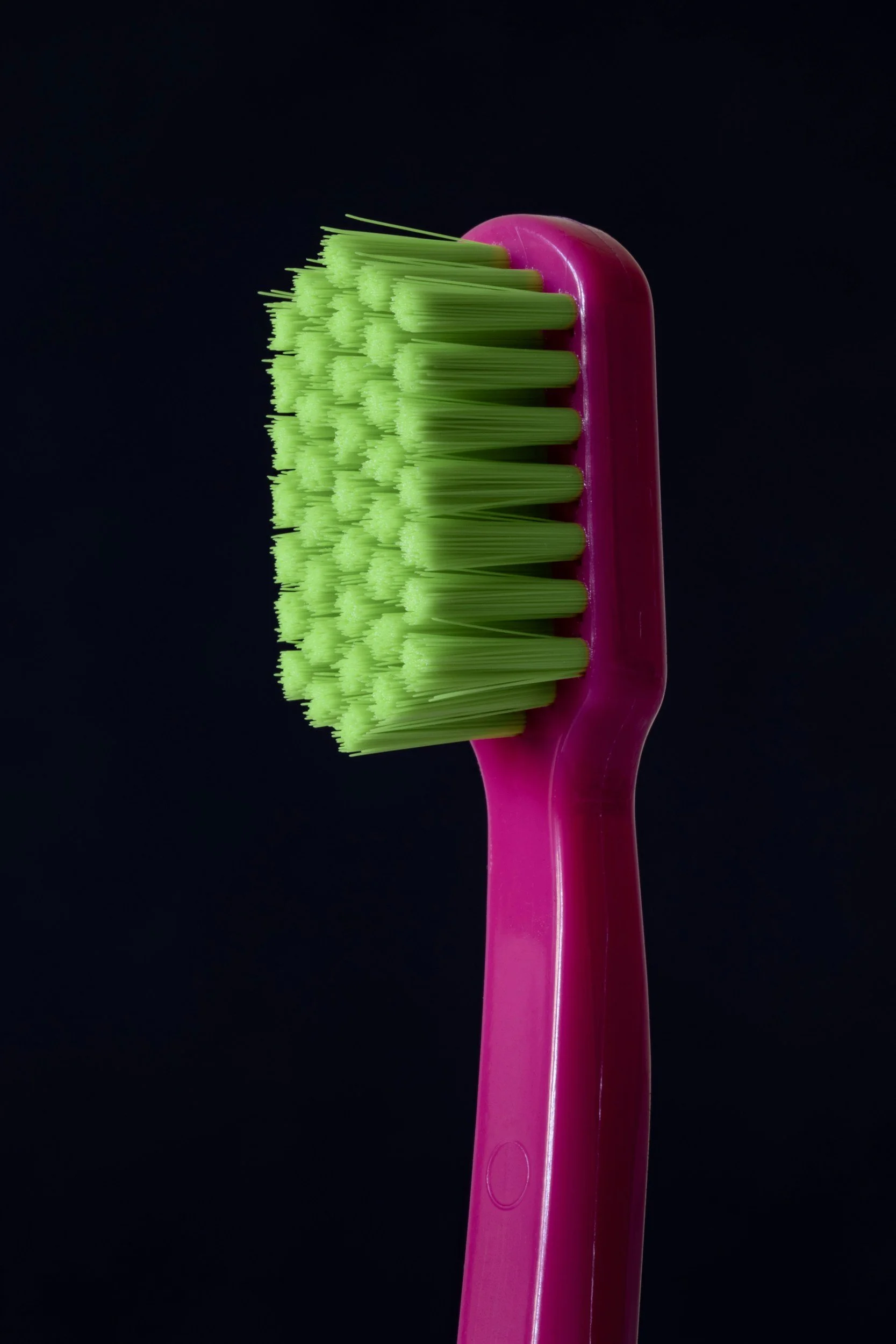 pink toothbrush with green bristles