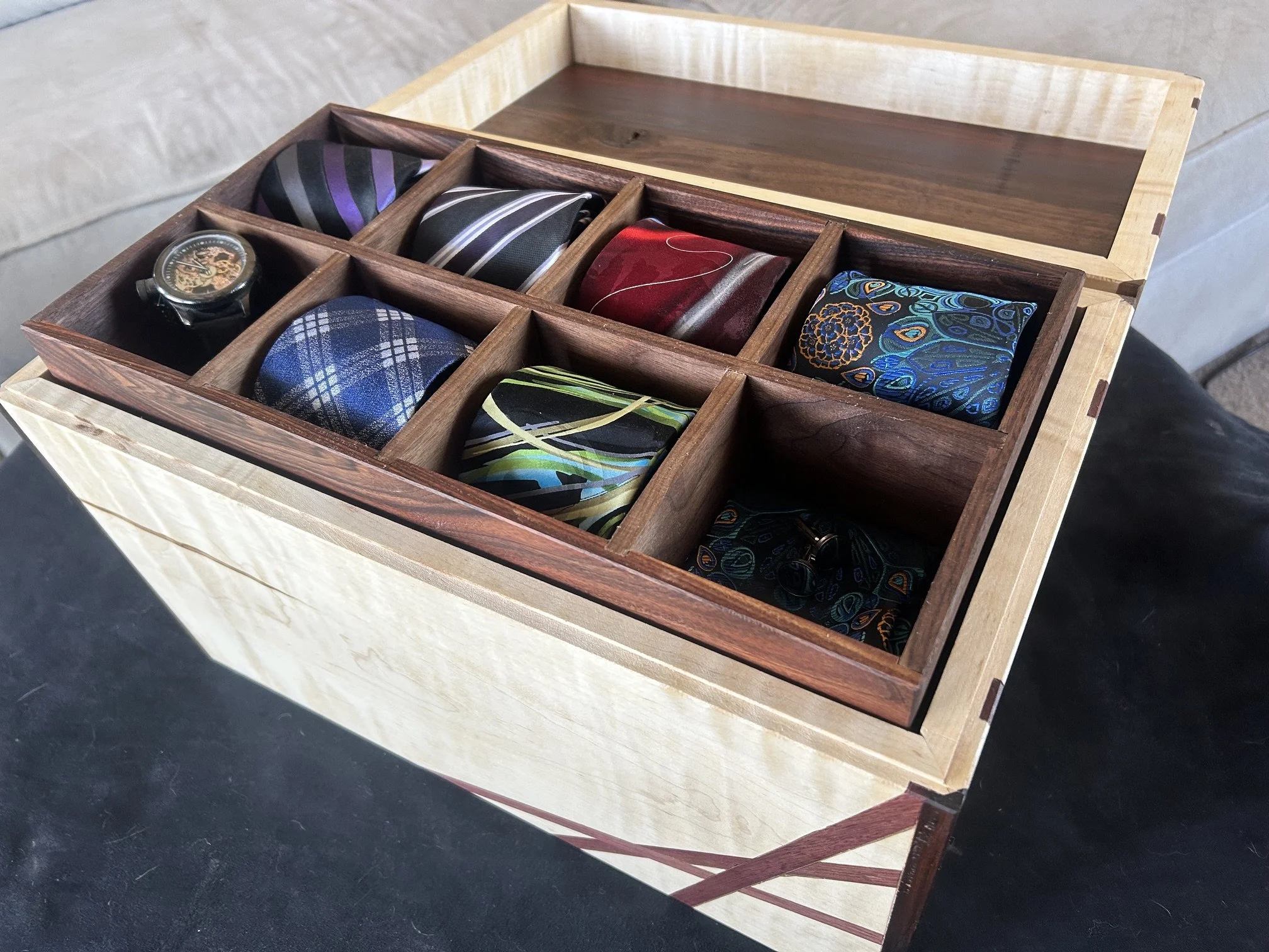 Jewelry box for men, made to hold ties, watches, cuff links, and any other items to make one feel fancier. Made from tiger maple with light spalting, morado, and walnut, with purpleheart accent.
