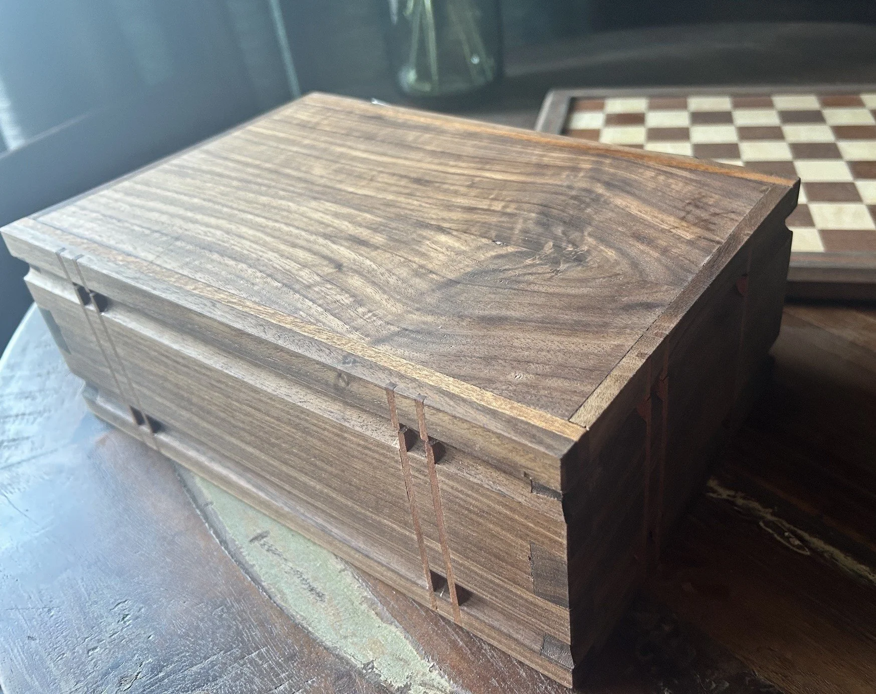 Walnut box with bookmatched lid, sapele accents, and handcut dovetail joints.