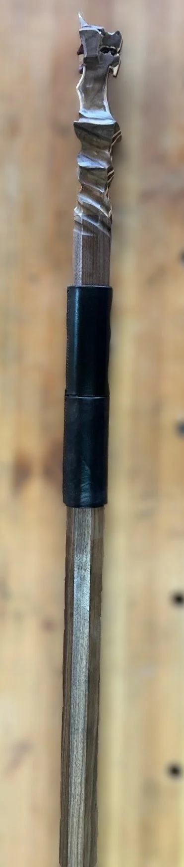Walnut wizard staff with hand carved dragon heapiece, accented with bloodwood and maple. Black leather pole wrap.