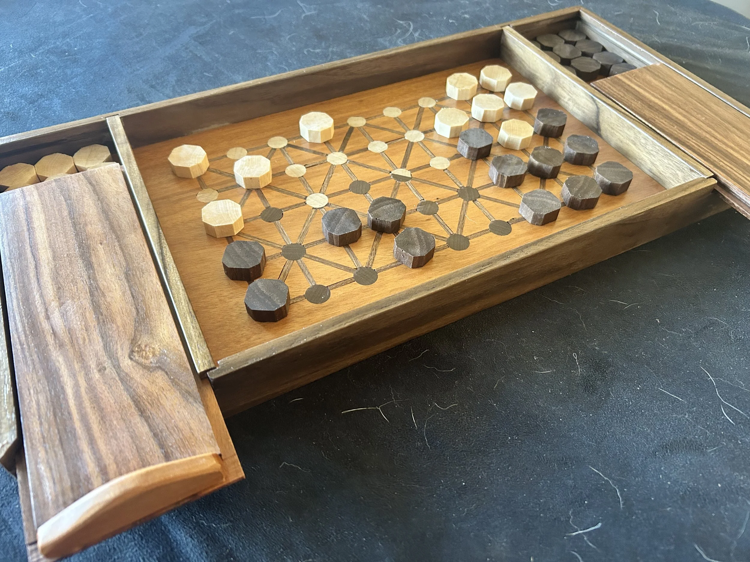 Fanorona board made with goncalo alves, walnut, and morado, with maple and walnut inlay.