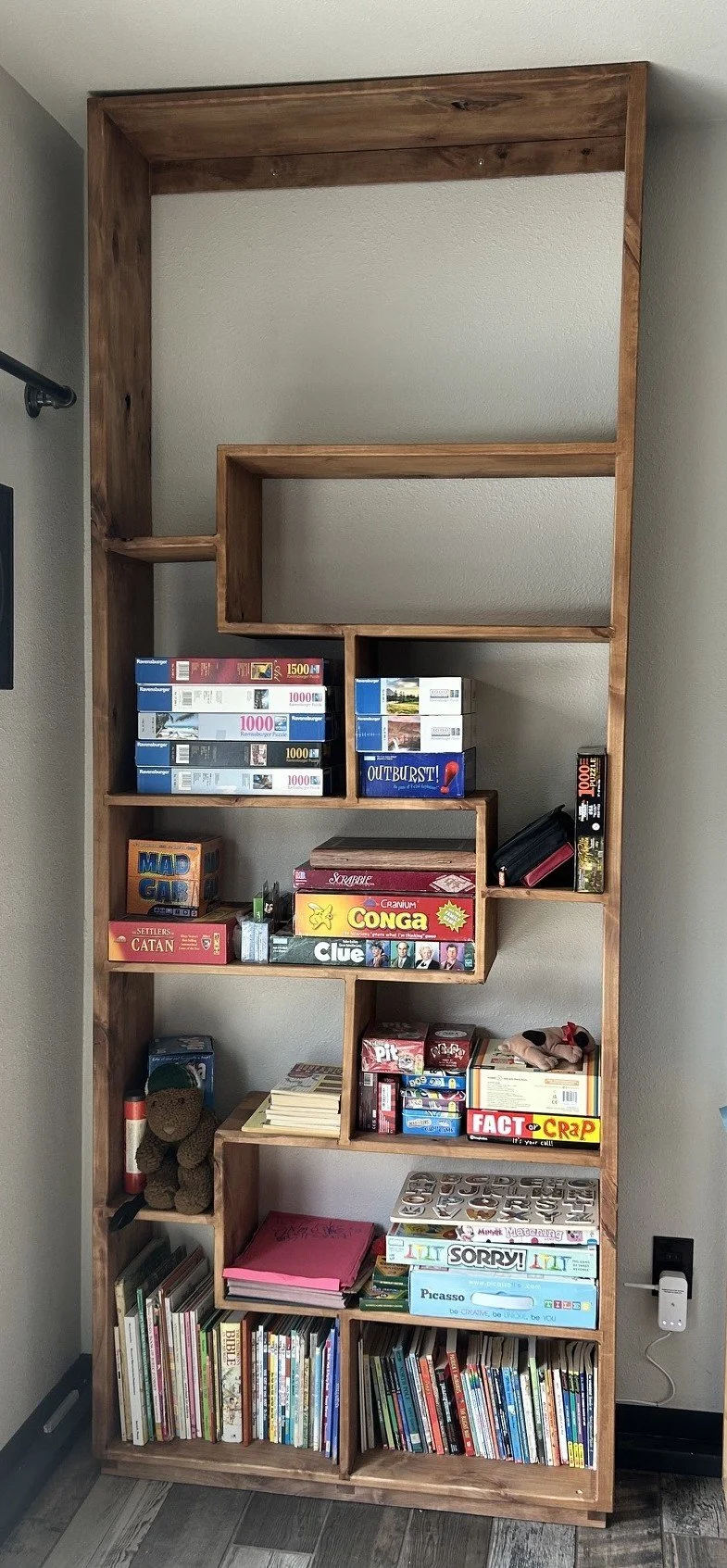 Custom floor-to-ceiling alder bookcase for holding board games.