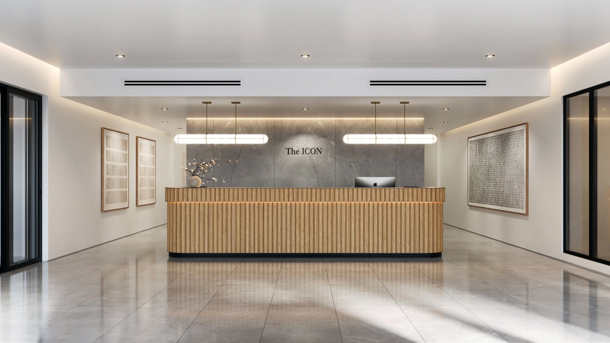 Modern hotel reception area with a wooden front desk, gray marble wall behind, illuminated sign reading 'The ICON', decorative vase with flowers, framed artwork on white walls, black framed glass doors, and large polished tile floor.