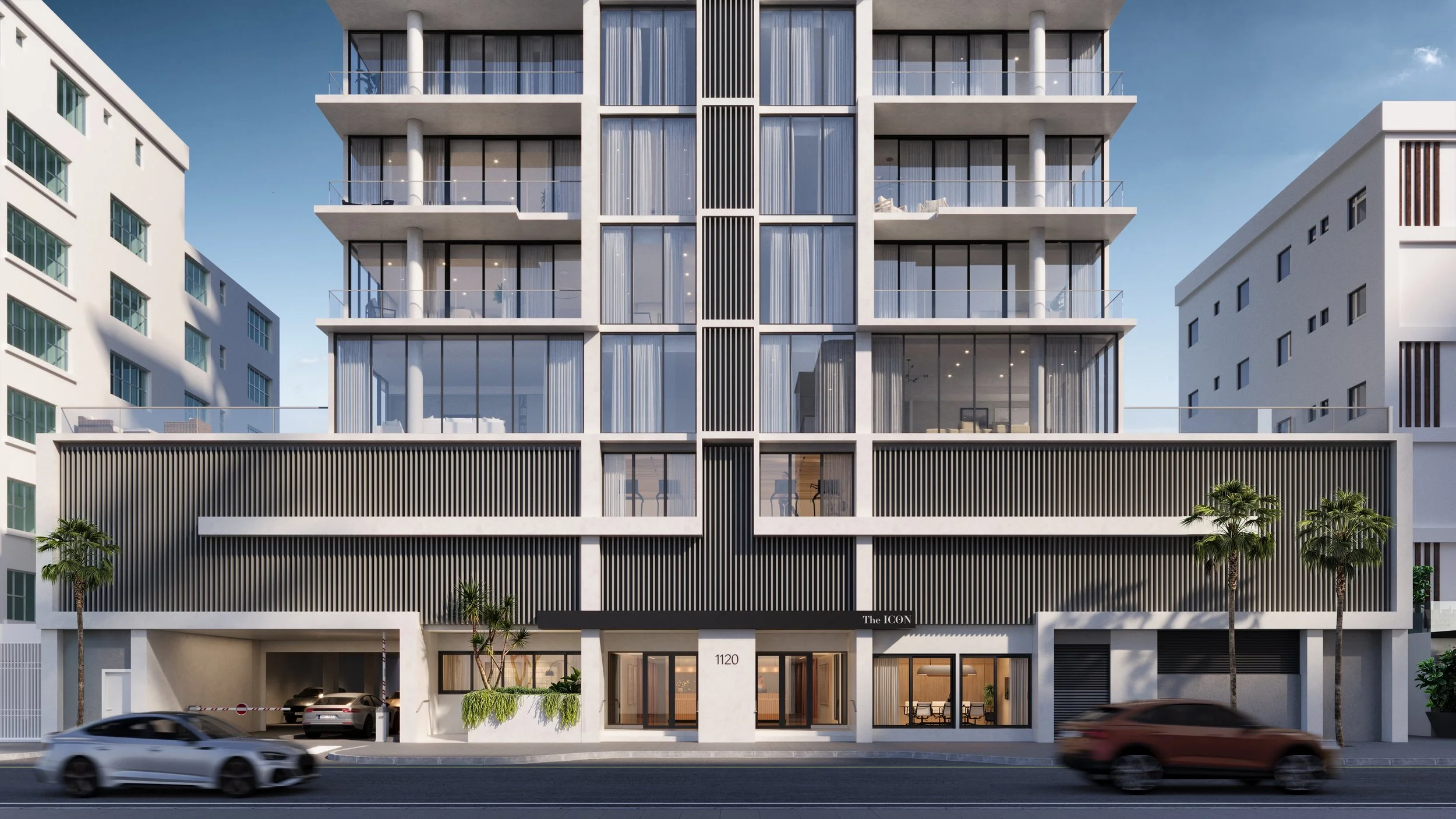 Modern multi-story residential building with large glass windows and balconies, situated on a city street with cars passing by.