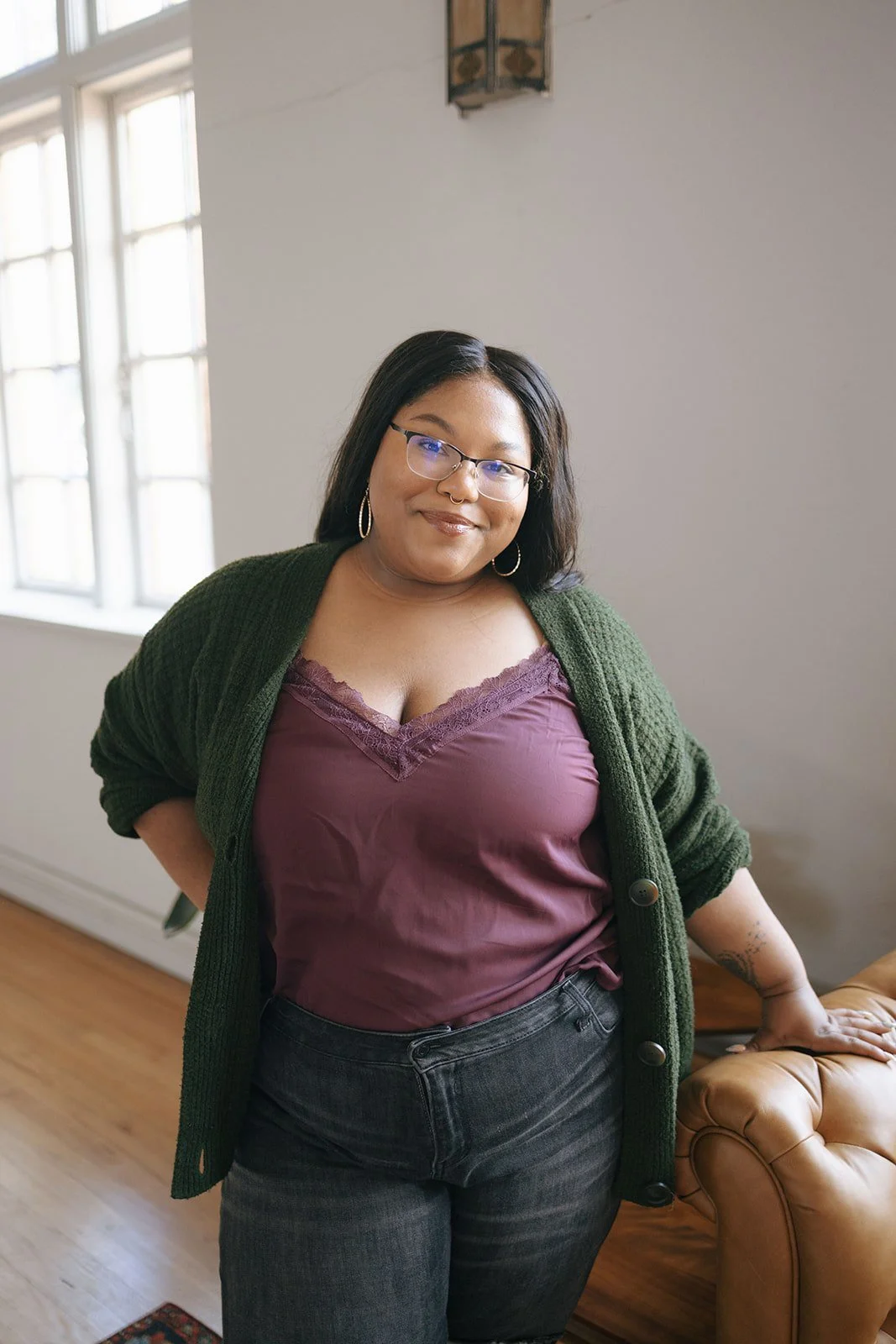 Tyler smiling with glasses and dark hair in a cardigan — psychodynamic therapist supporting emotional healing in Kyle, TX and telehealth.