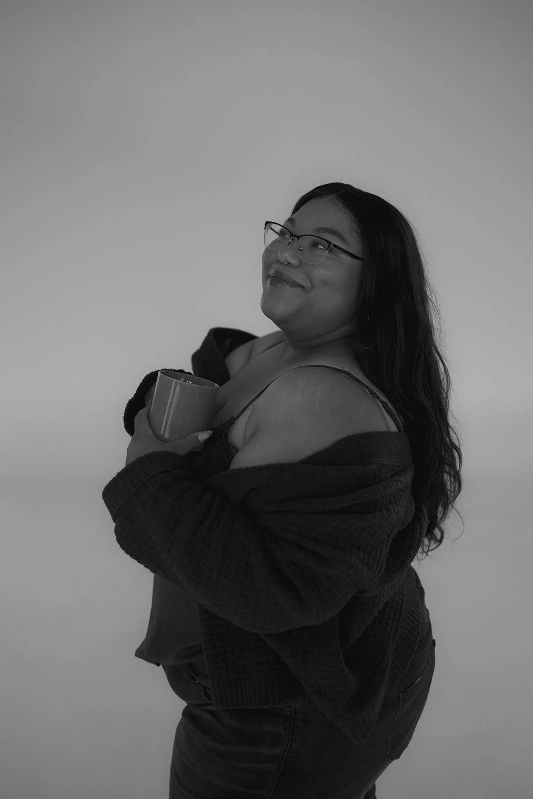 Tyler smiling with glasses and dark hair in a cardigan — psychodynamic therapist supporting emotional healing in Kyle, TX and telehealth.