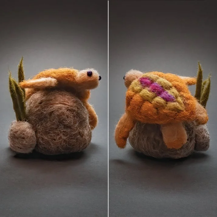 Two felted wool creatures resembling plants or animals with main bodies, small appendages, and colorful felted decorations, set against a gray background.