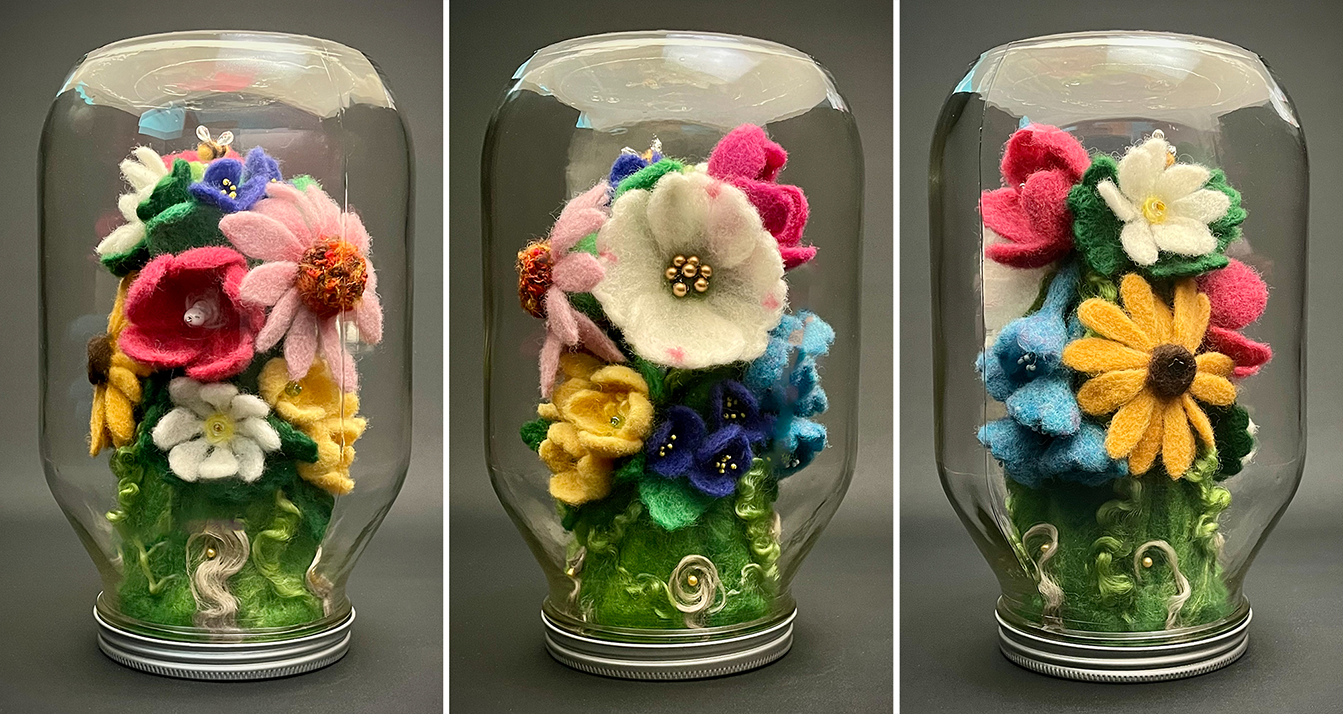 Felted wool flowers arranged inside a glass jar.
