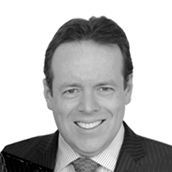 Black and white portrait of a man in a suit smiling