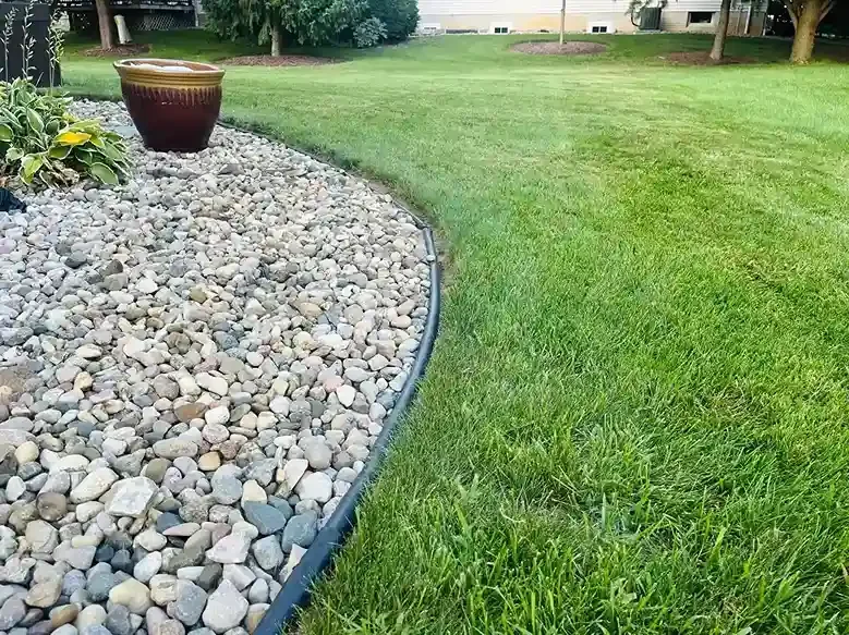 Rock garden border beside a neatly cut lawn in a Michigan residential yard.