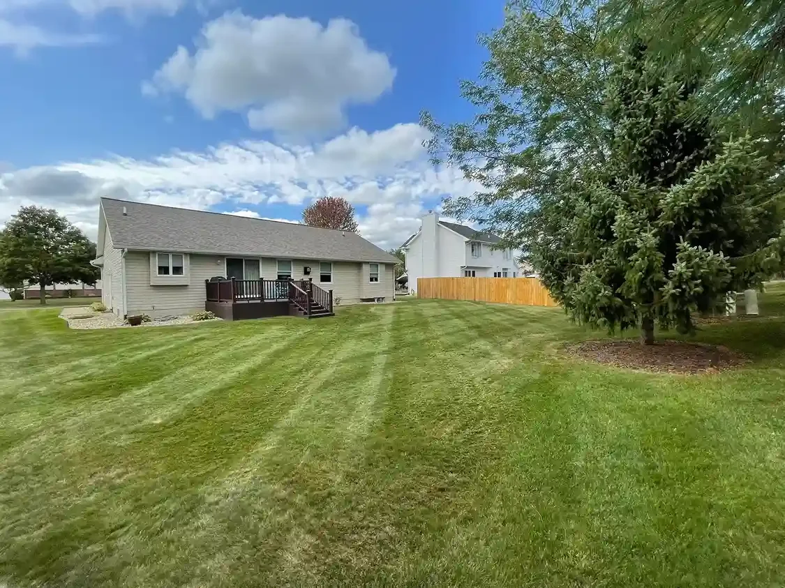 Residential lawn with fresh mowing stripes maintained by Michigan Lawn Care.