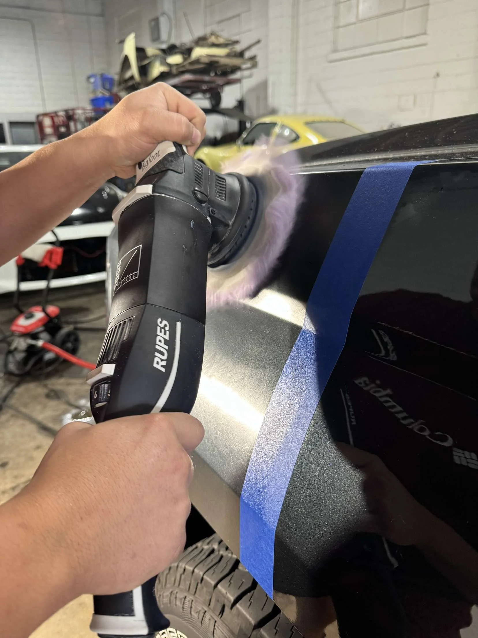 Person using a RUPES polishing tool on a black vehicle, to ensure paint correction is demonstrated well. Cookeville, Tn.