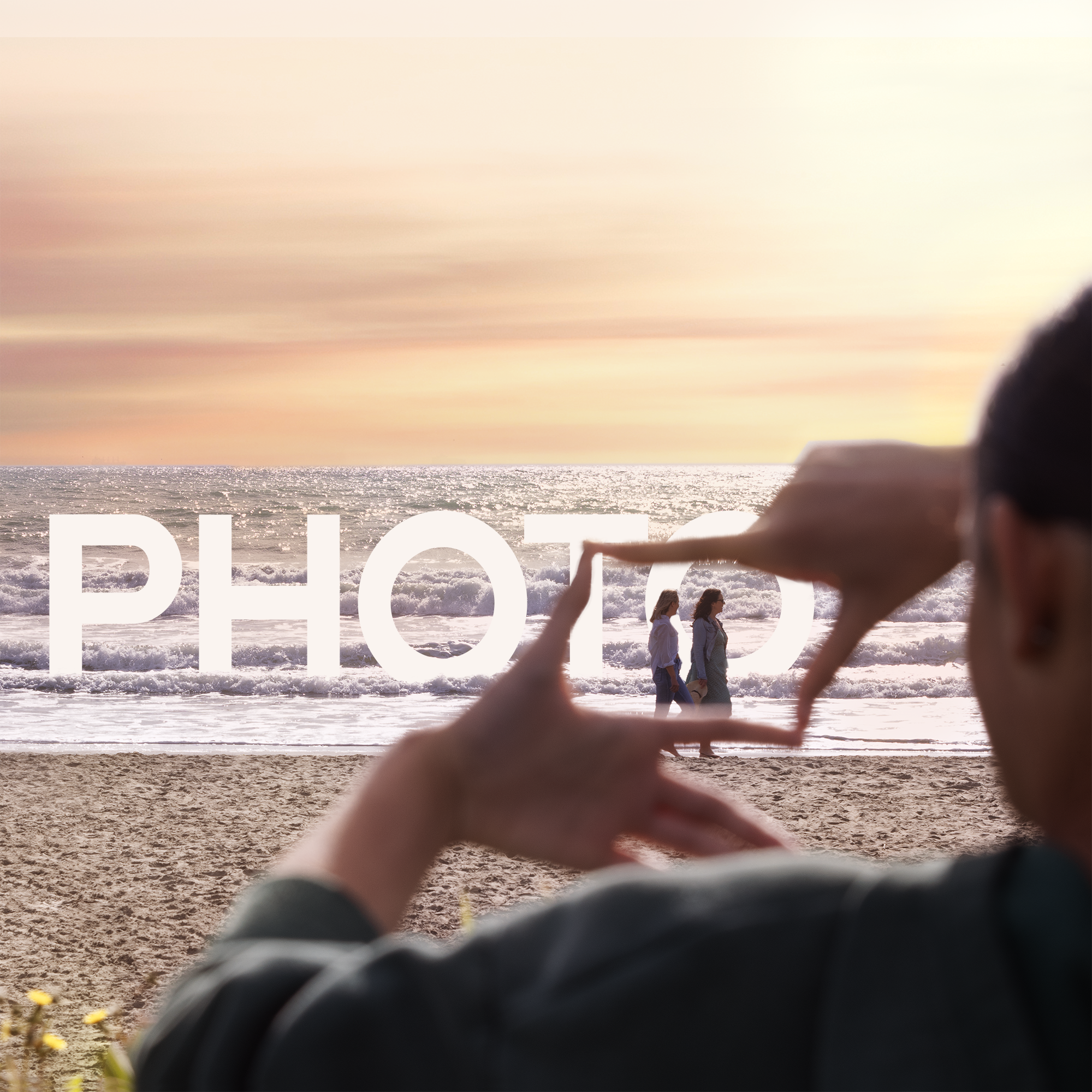 Women making a photo square with her fingers on beach 2 women walking on beach Sumner Christchurch NZ_Photo letters in ocean