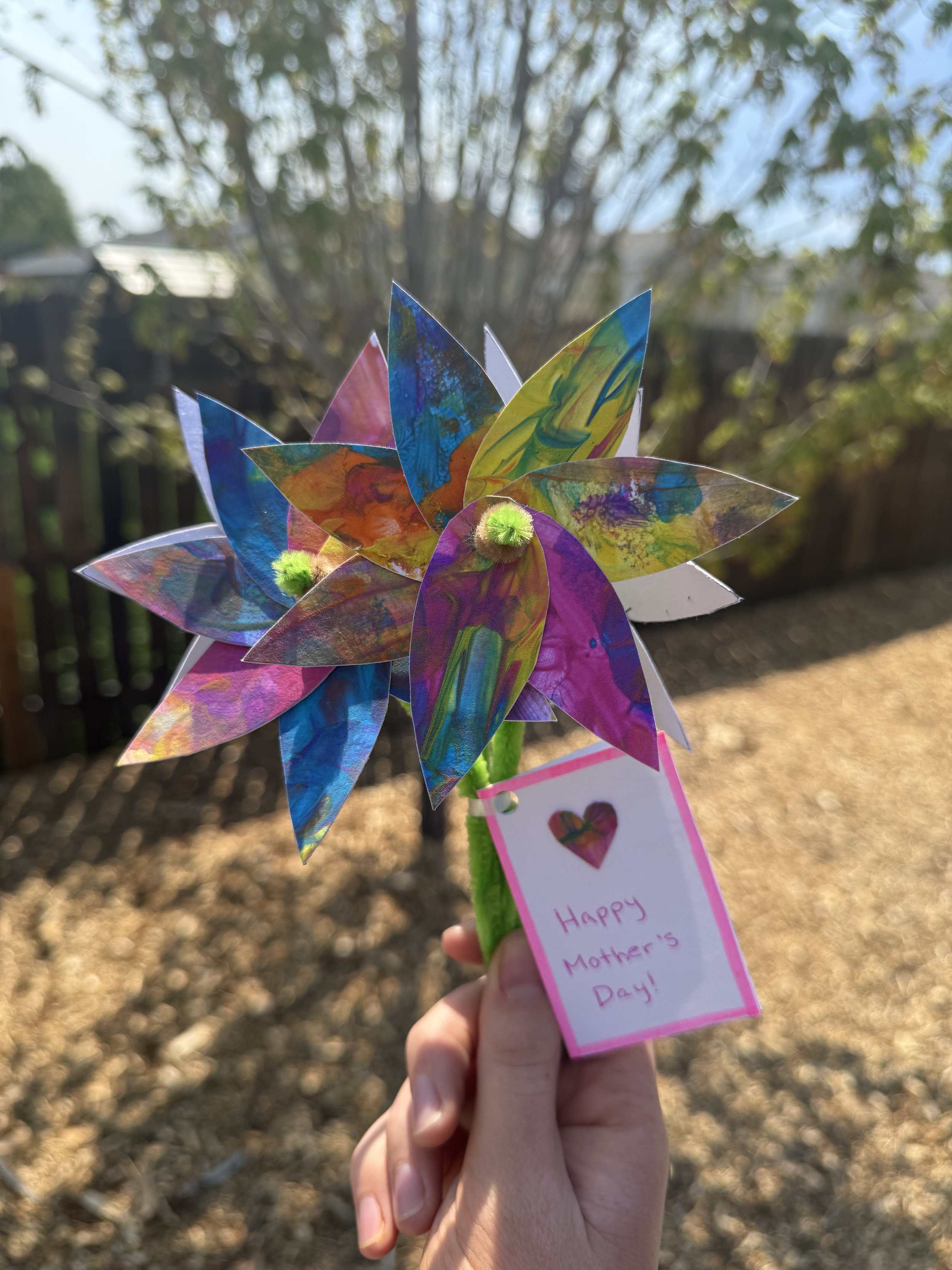 Colorful artificial flower with a pink tag that says 'Happy Mother’s Day!'