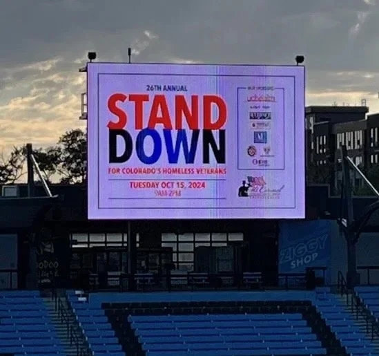 Large electronic billboard displaying information about the 26th annual Stand Down event for Colorado's homeless veterans, scheduled for Tuesday, October 15, 2024.