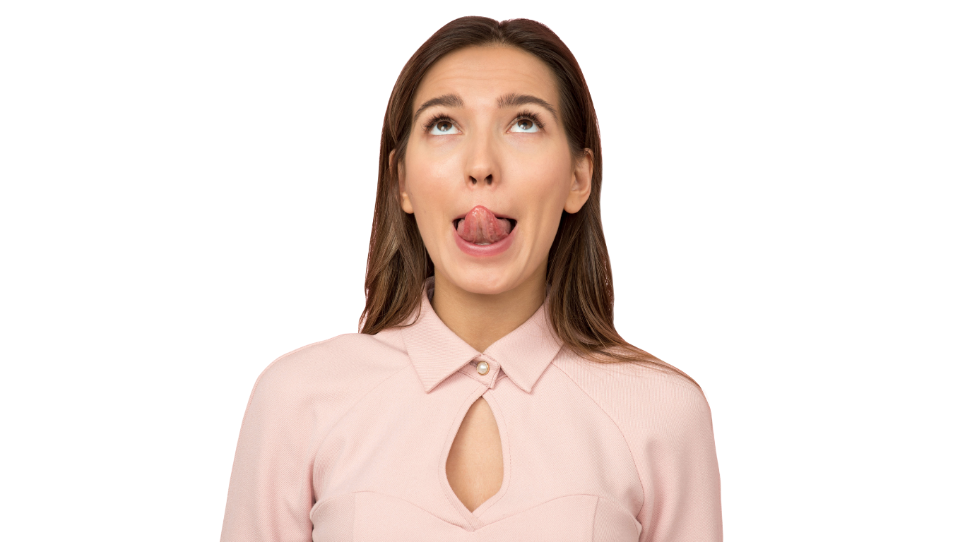 A young woman with brown hair, wearing a light pink top, sticking out her tongue and looking upwards. Myofunctional Therapy Exercise. Myo.