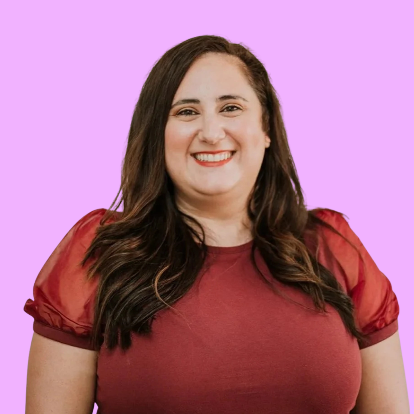 A woman with long dark brown hair smiling against a purple background.