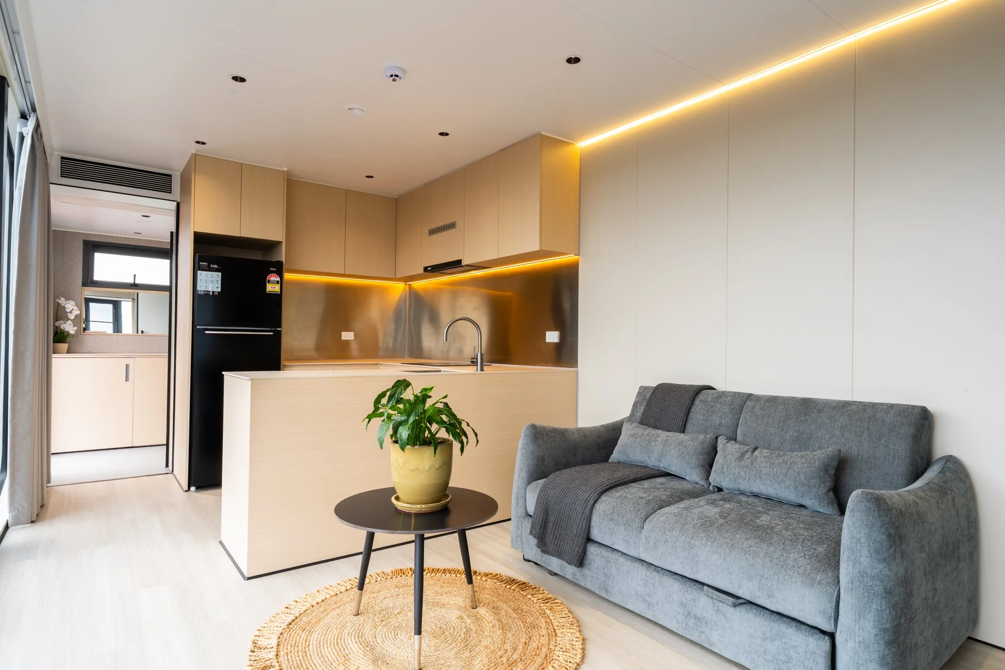 AUZPOD portable pod house living area with integrated kitchen, showcasing sustainable modular home interior design in Australia.