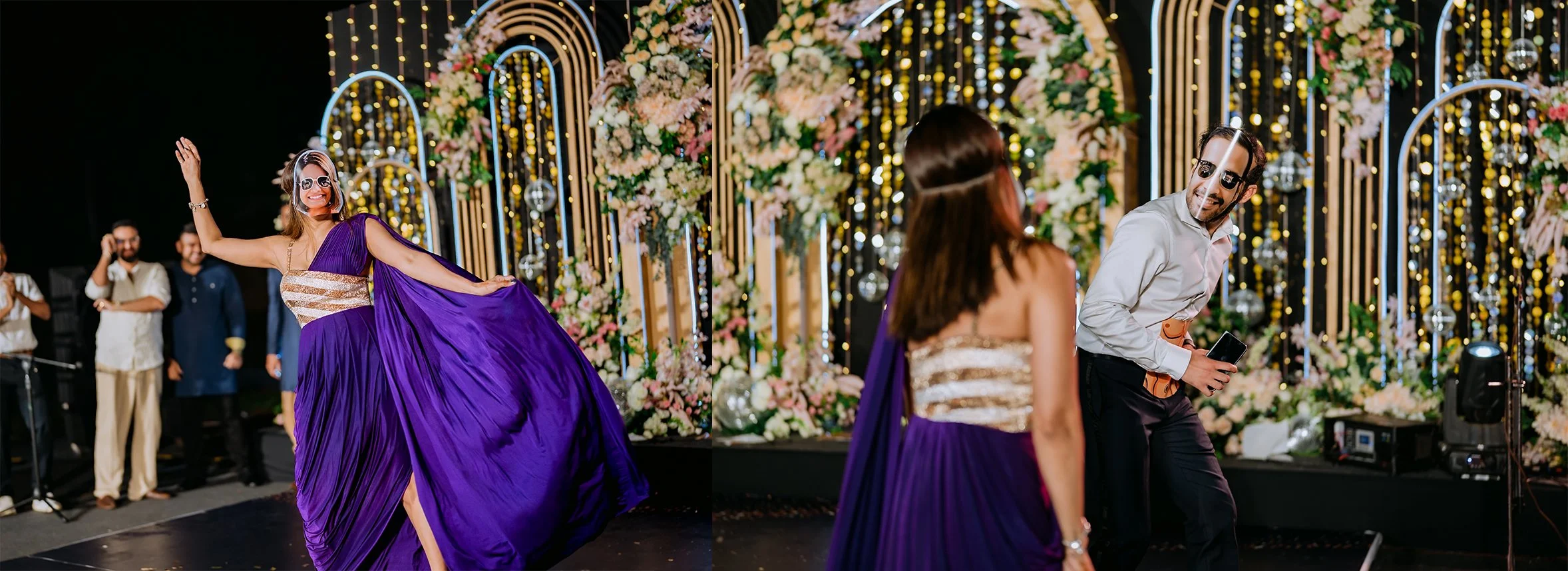 People dancing and celebrating at a wedding reception with a decorated floral and light backdrop.