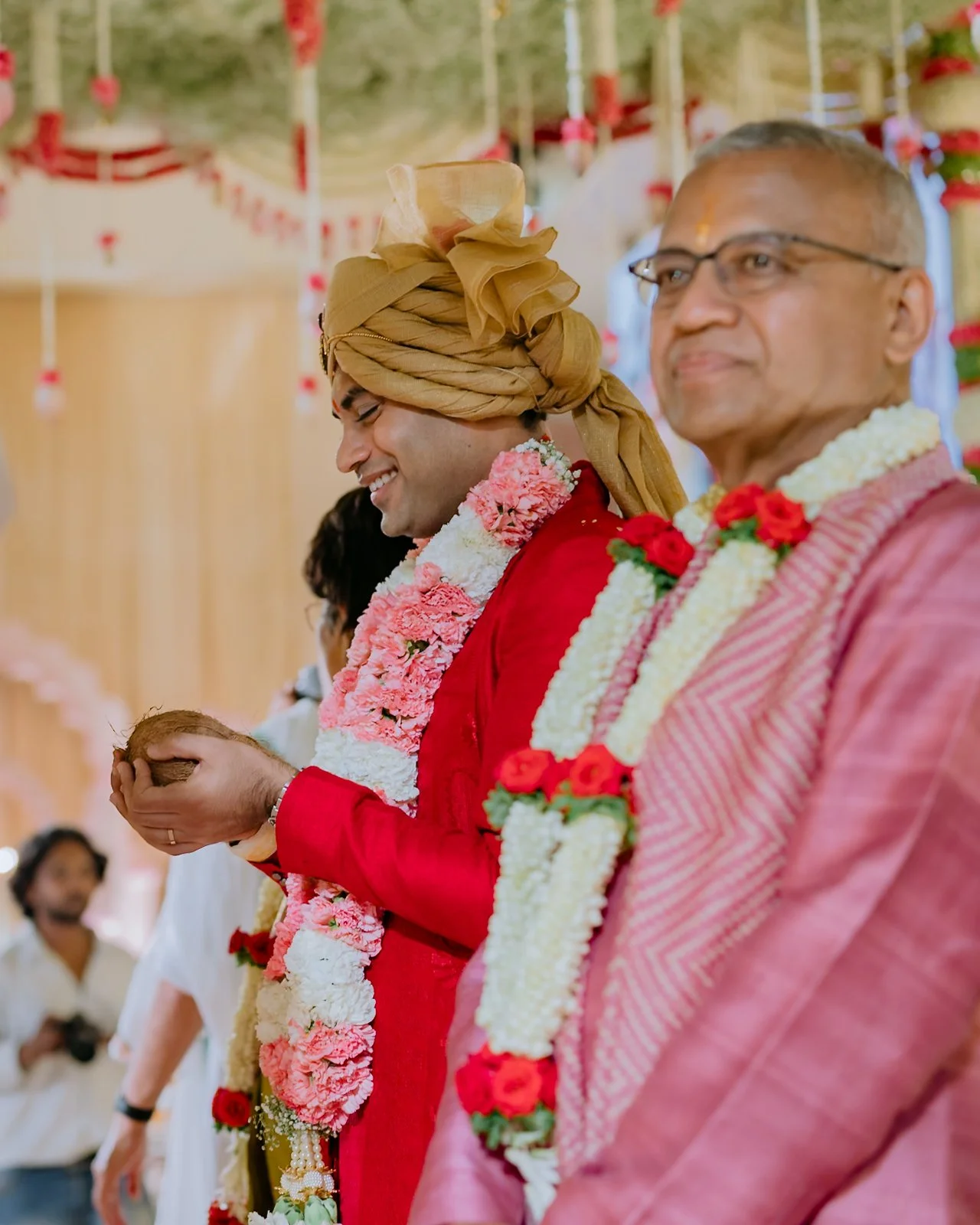 Akhil and his father at the mandap holding the ceremonial coconut