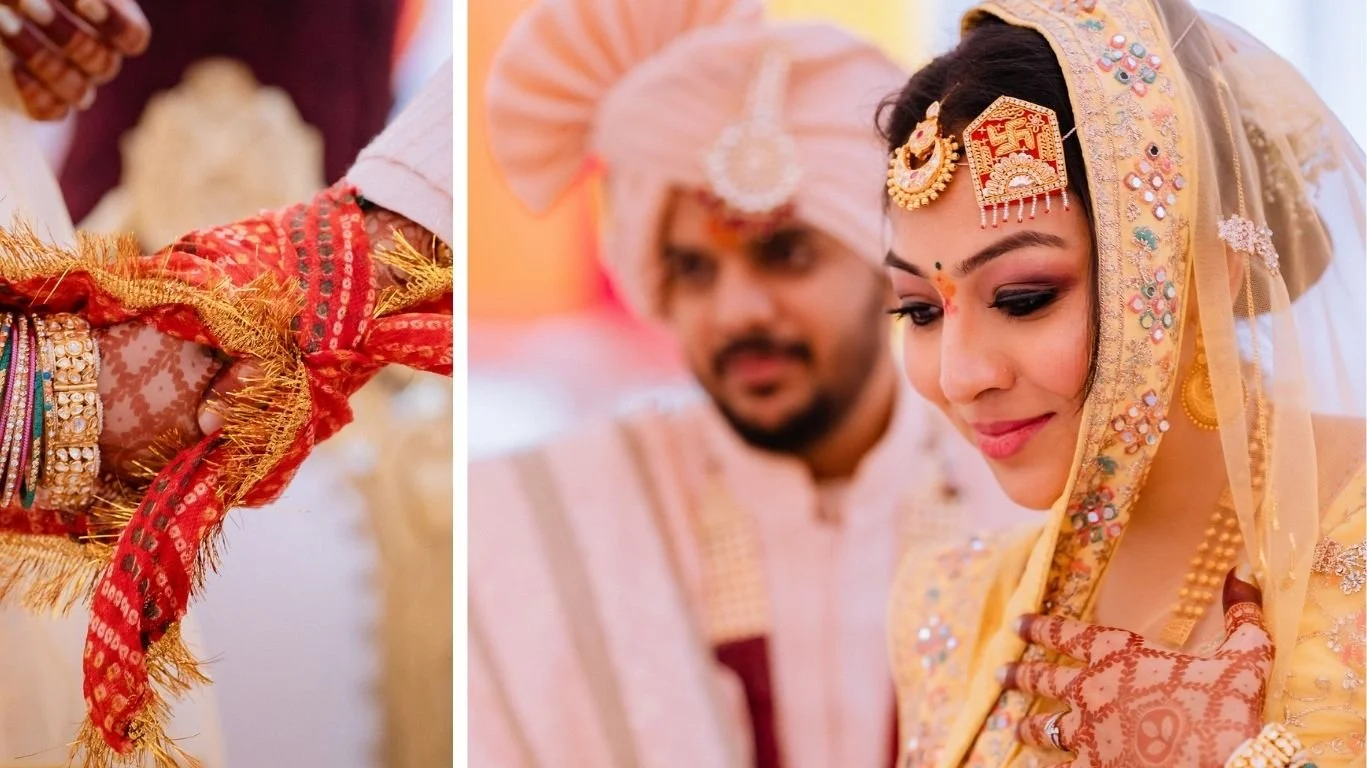 Close-up of a bride and groom during a traditional Indian wedding, with the focus on the bride's intricate henna hands and elaborate jewelry. The bride is dressed in a gold and pastel-colored bridal outfit with detailed embroidery and makeup, while t