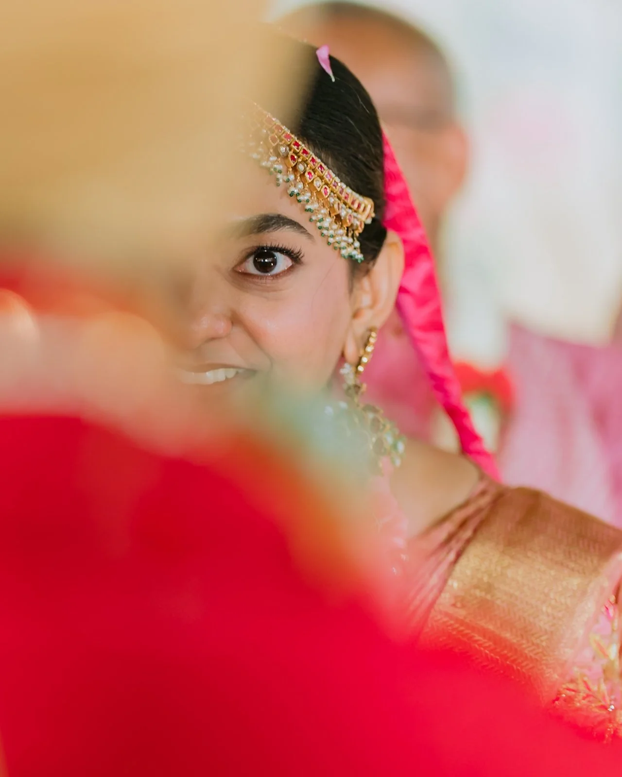 Shrishti's eyes looking at Akhil past his red shoulder
