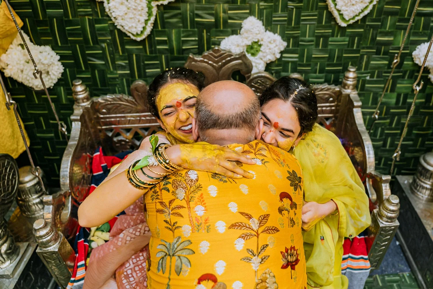 Shrishti and her sister hugging their father at the haldi