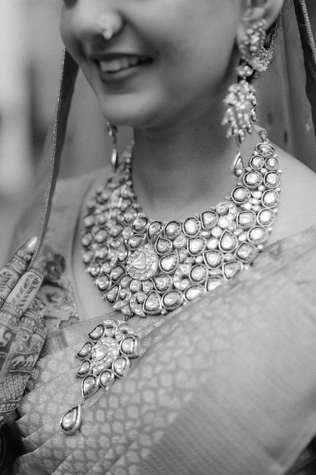 Close-up of Shrishti's bridal necklace and earrings, black and white