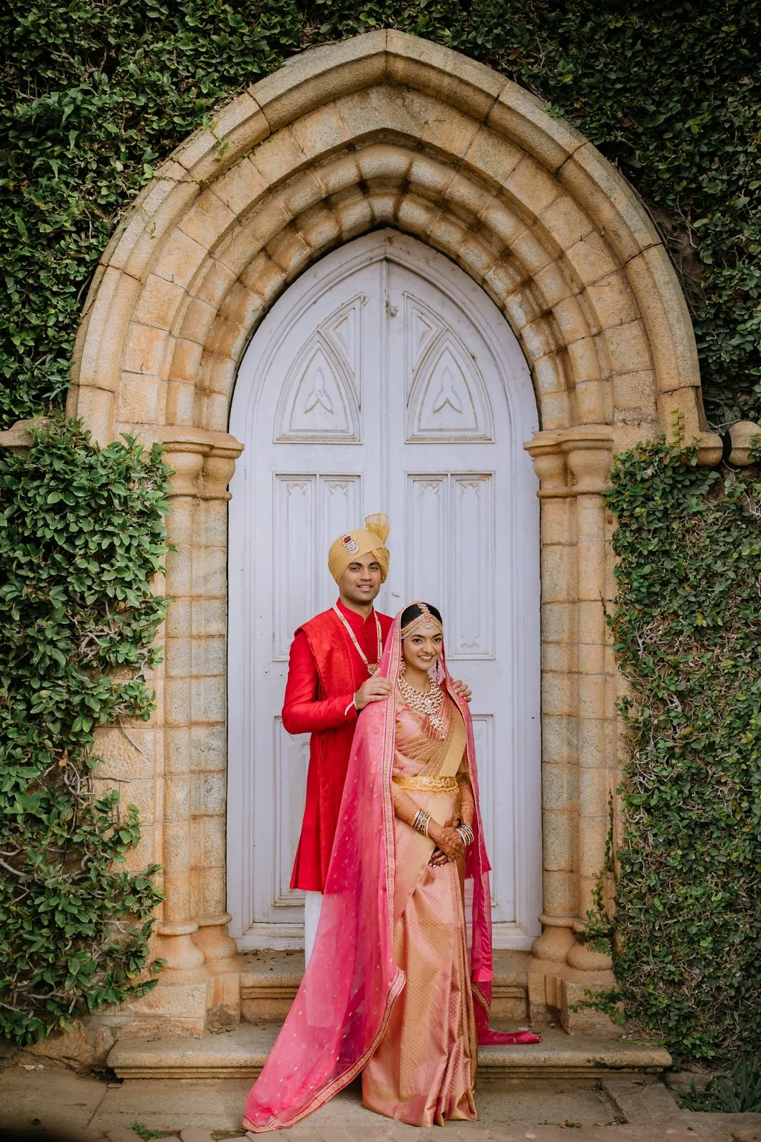 Shrishti and Akhil standing together at an arched palace doorway