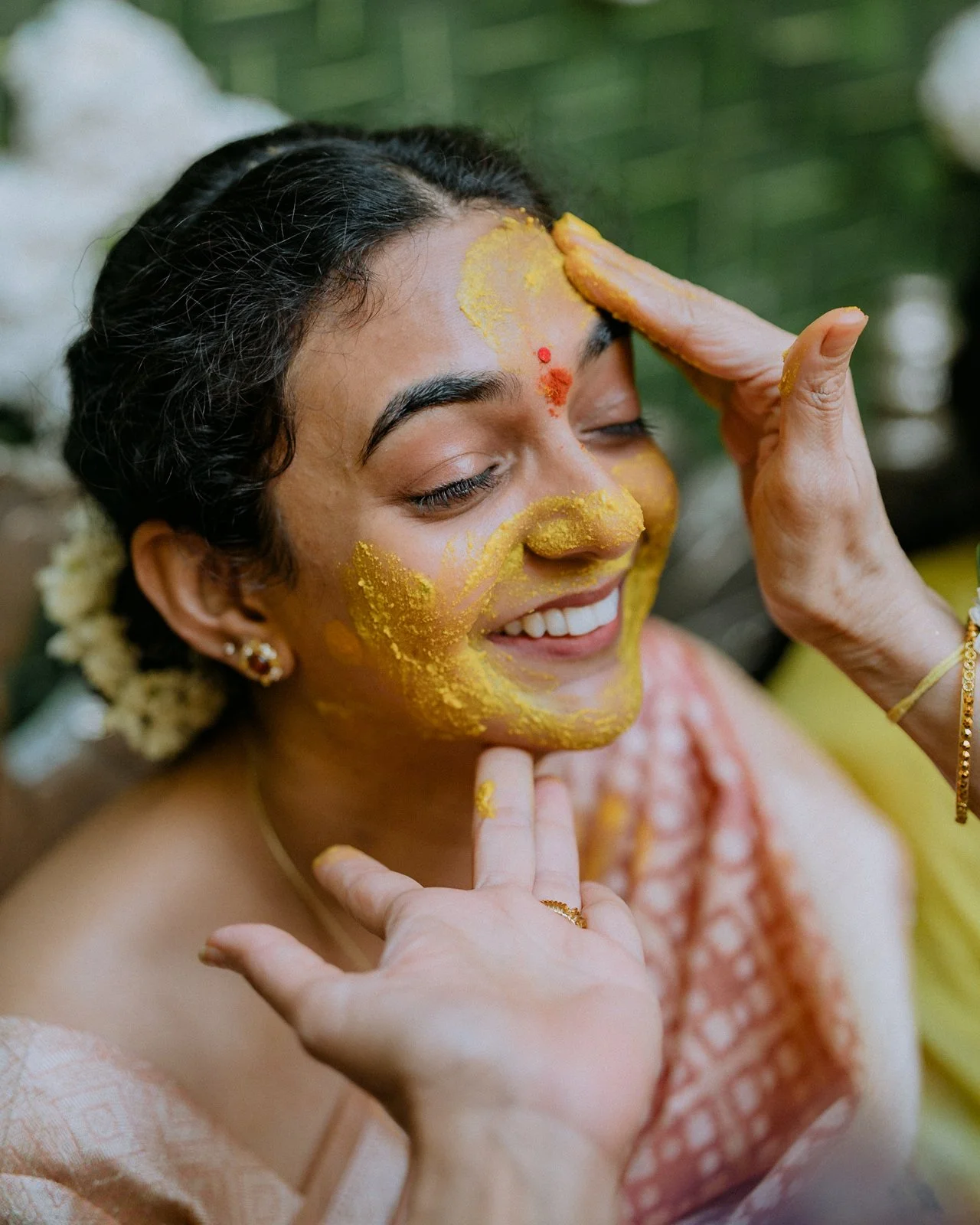 Close-up of turmeric being applied to Shrishti's face