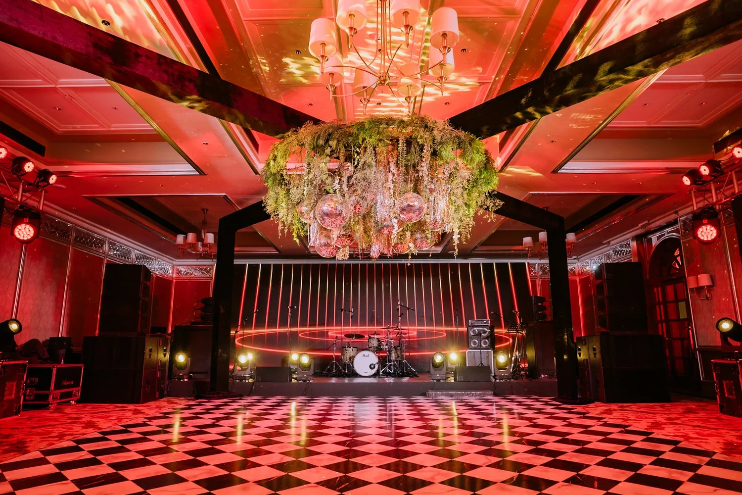 Taj West End ballroom lit in red with a floral chandelier