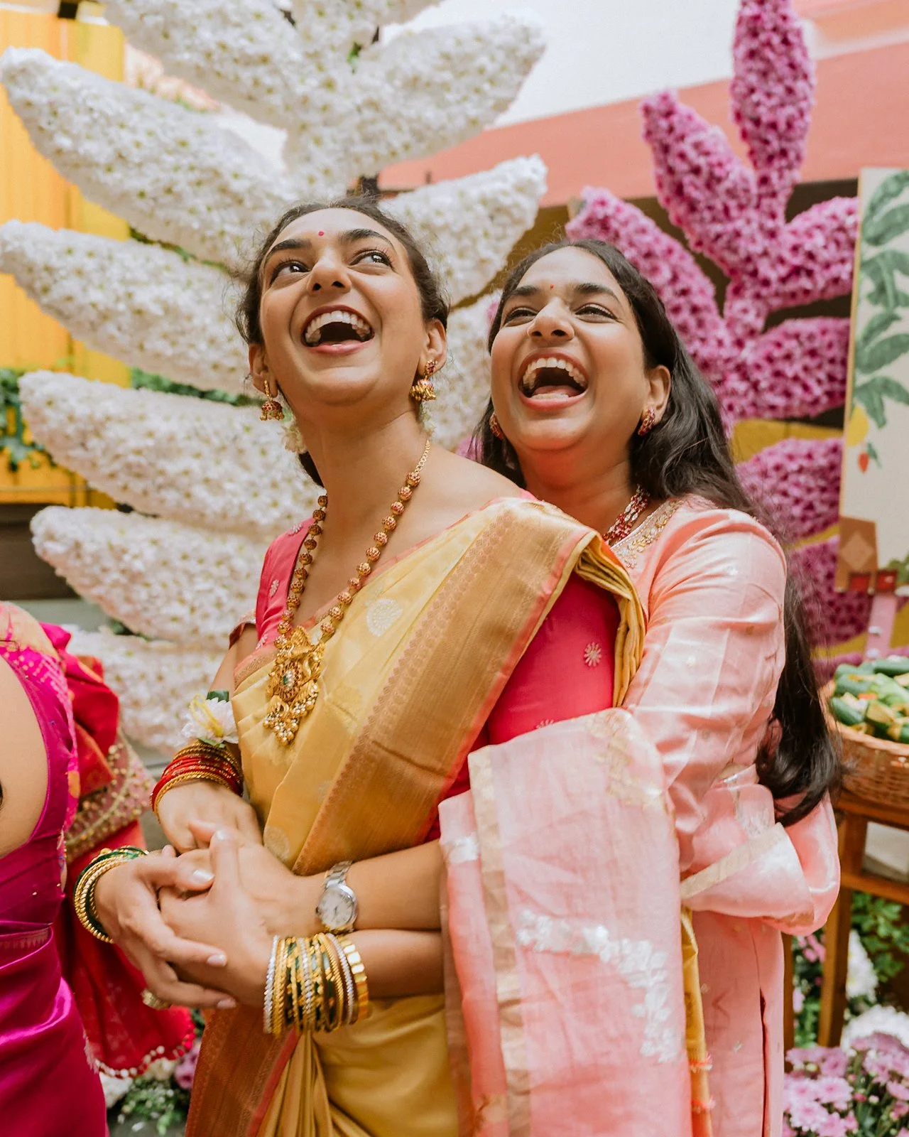 Shrishti laughing as her sister hugs her from behind at the haldi