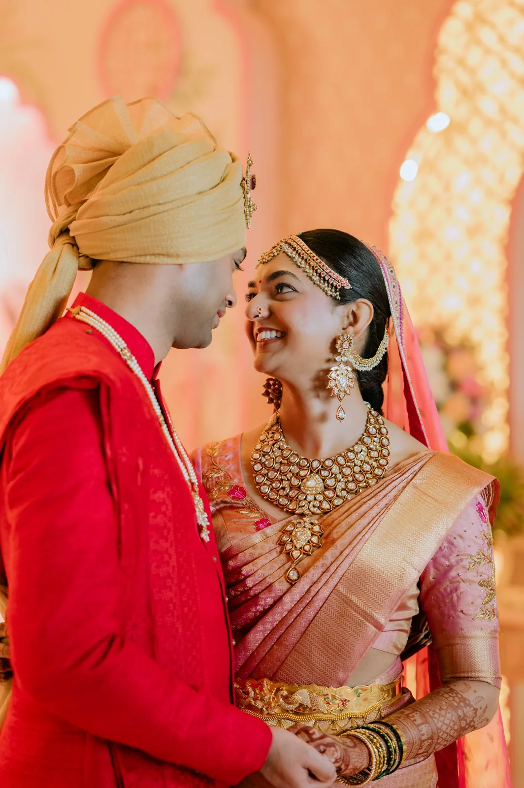 Shrishti and Akhil smiling at each other in their wedding clothes