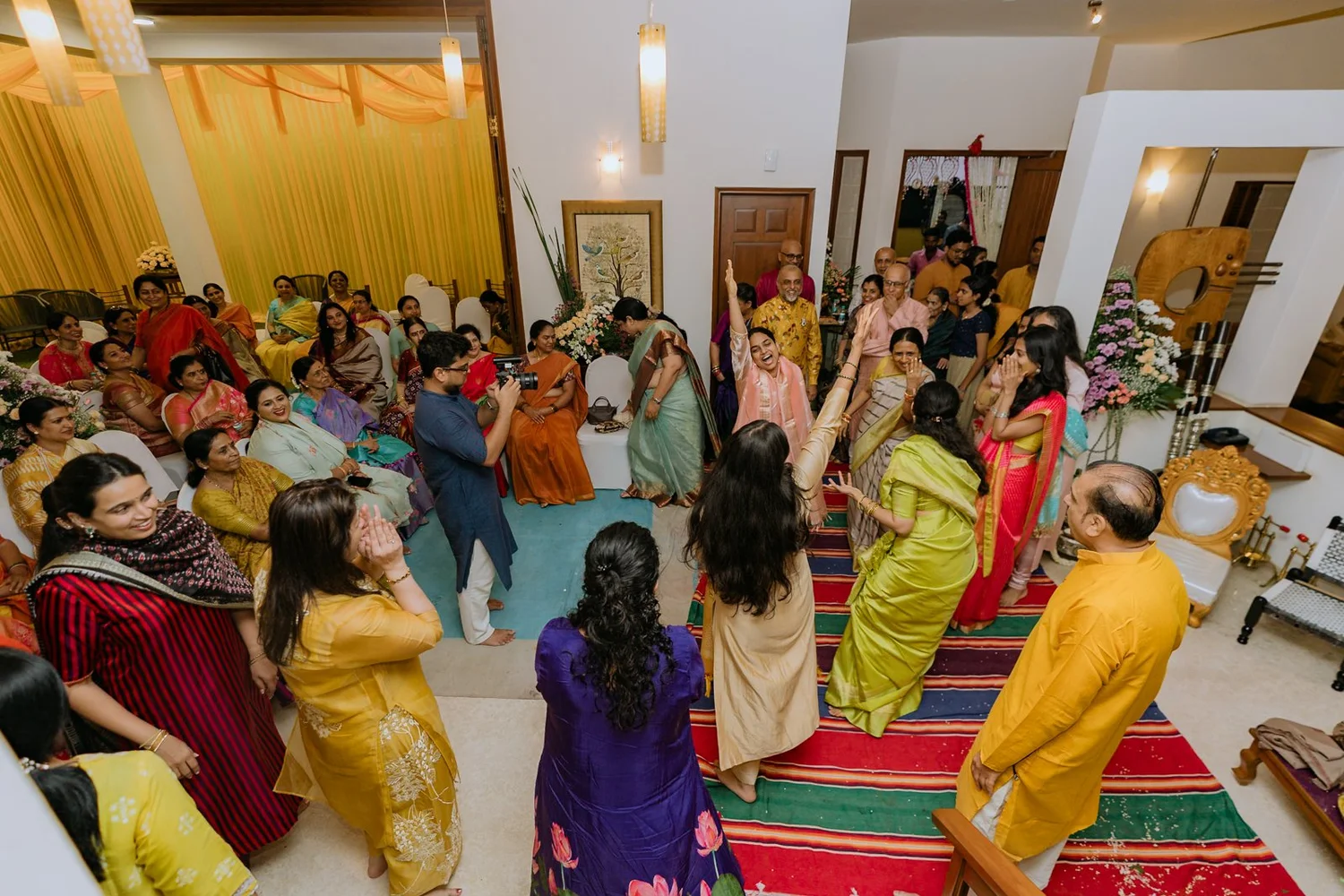 Family gathered around the dancing at the haldi