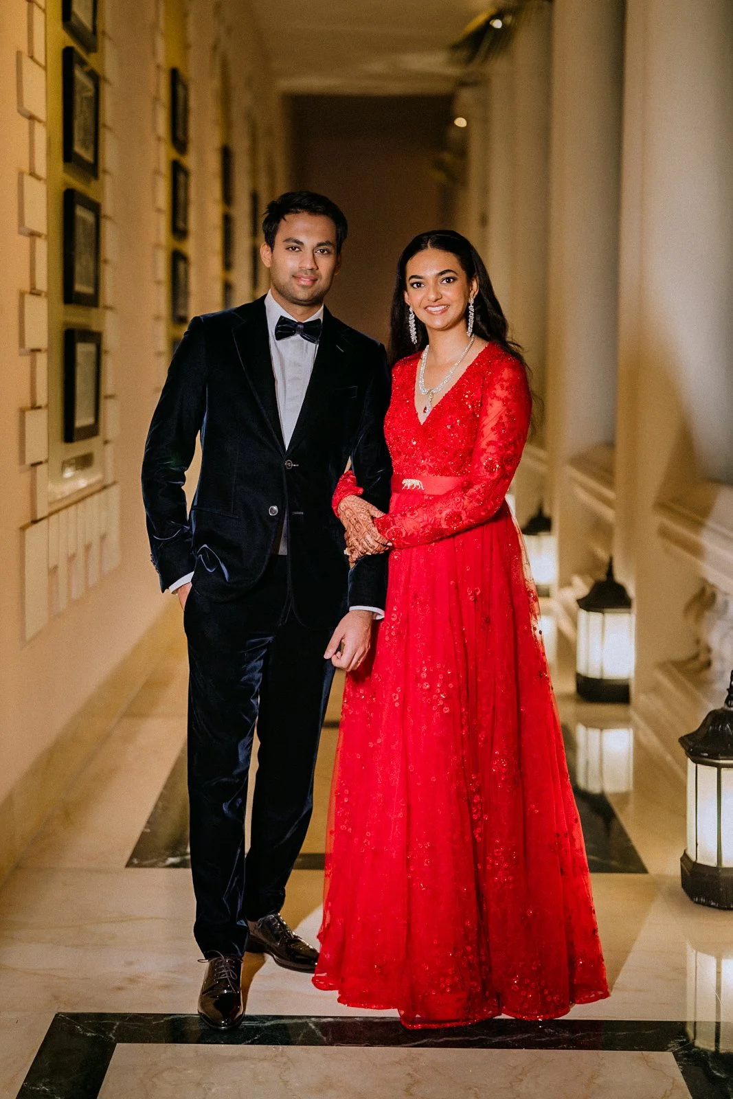 Shrishti and Akhil in a red gown and tuxedo at Taj West End