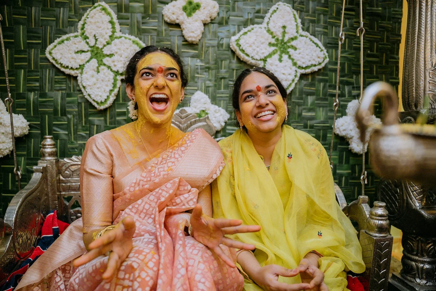 Shrishti and her sister laughing with haldi on their faces