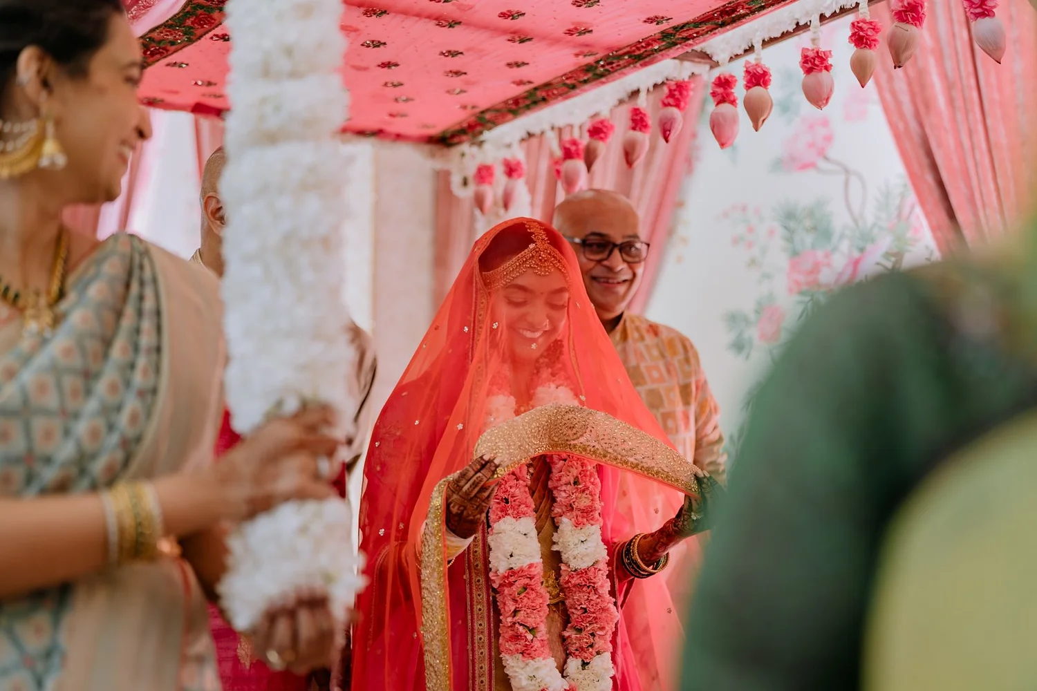 Bride smiling beneath the jasmine canopy as she walks in