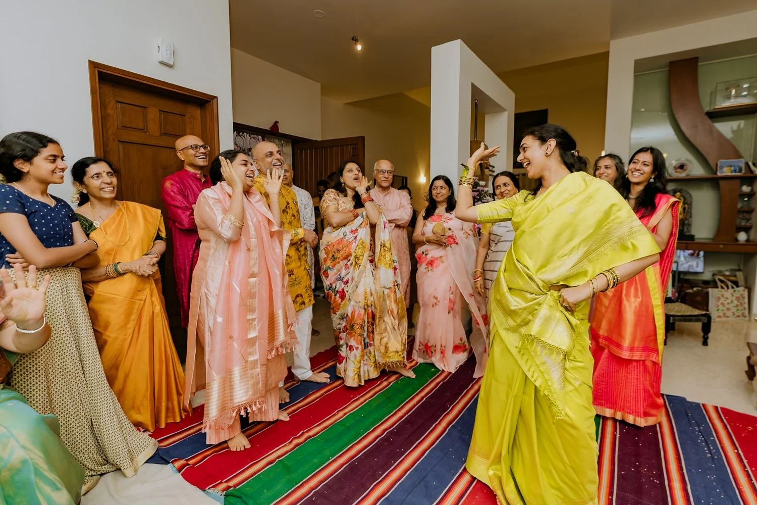 Women dancing and clapping in a circle at the haldi celebration